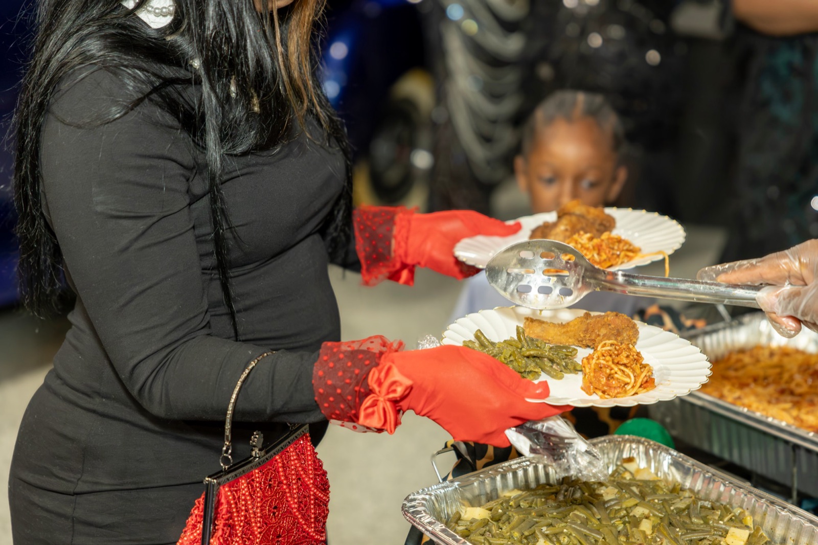 Guest being served fried chicken, spaghetti, and green beans at a DeMarv's Catering event