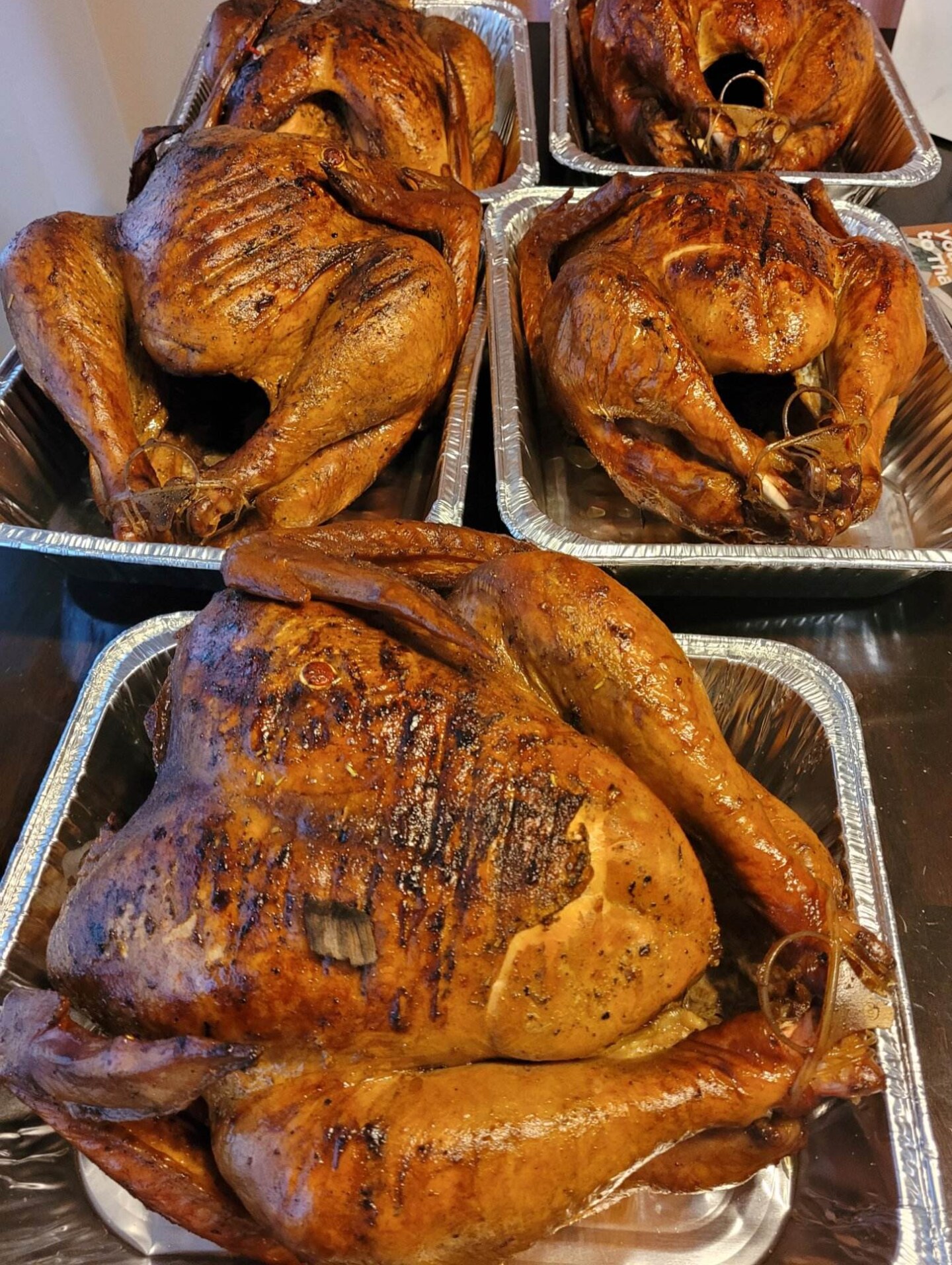 Four whole fried and smoked Thanksgiving turkeys, fresh out of the pans